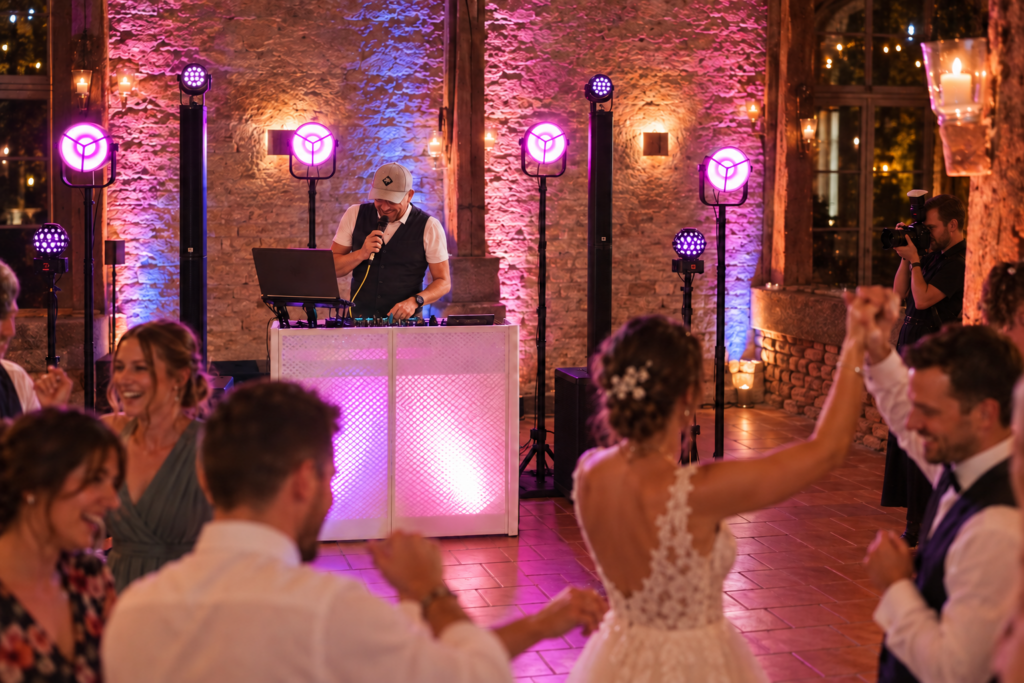 DJ Rico Cinsano mit seiner DJ-Technik, Hochzeitsfotograf und Gäste auf einer gut gefüllten Tanzfläche